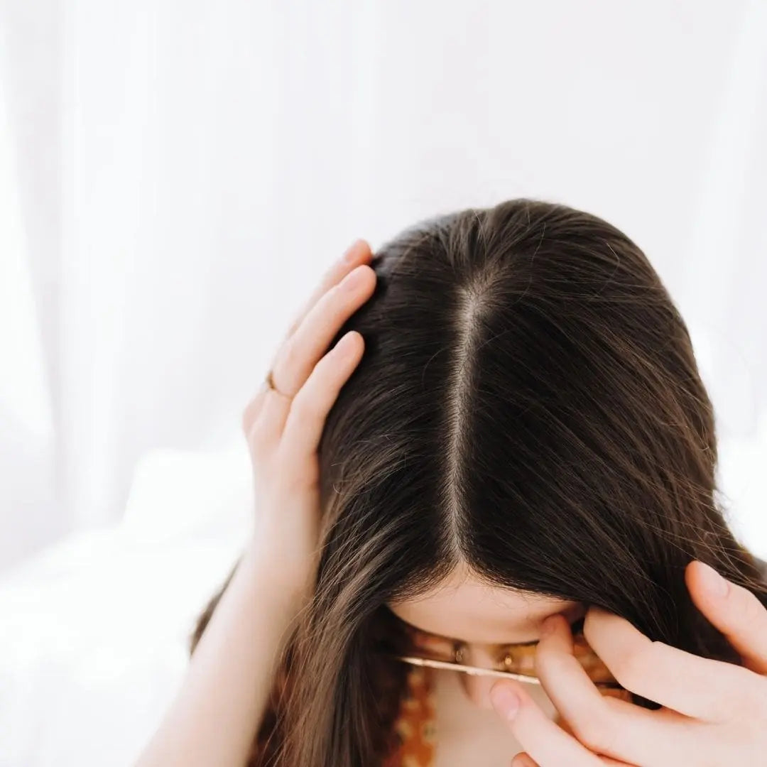 Femme qui se touche les cheveux - LAO - Cheveux au naturel - Soins lavants 100% d'origine naturelle - Shampoings sans sulfates ni silicones