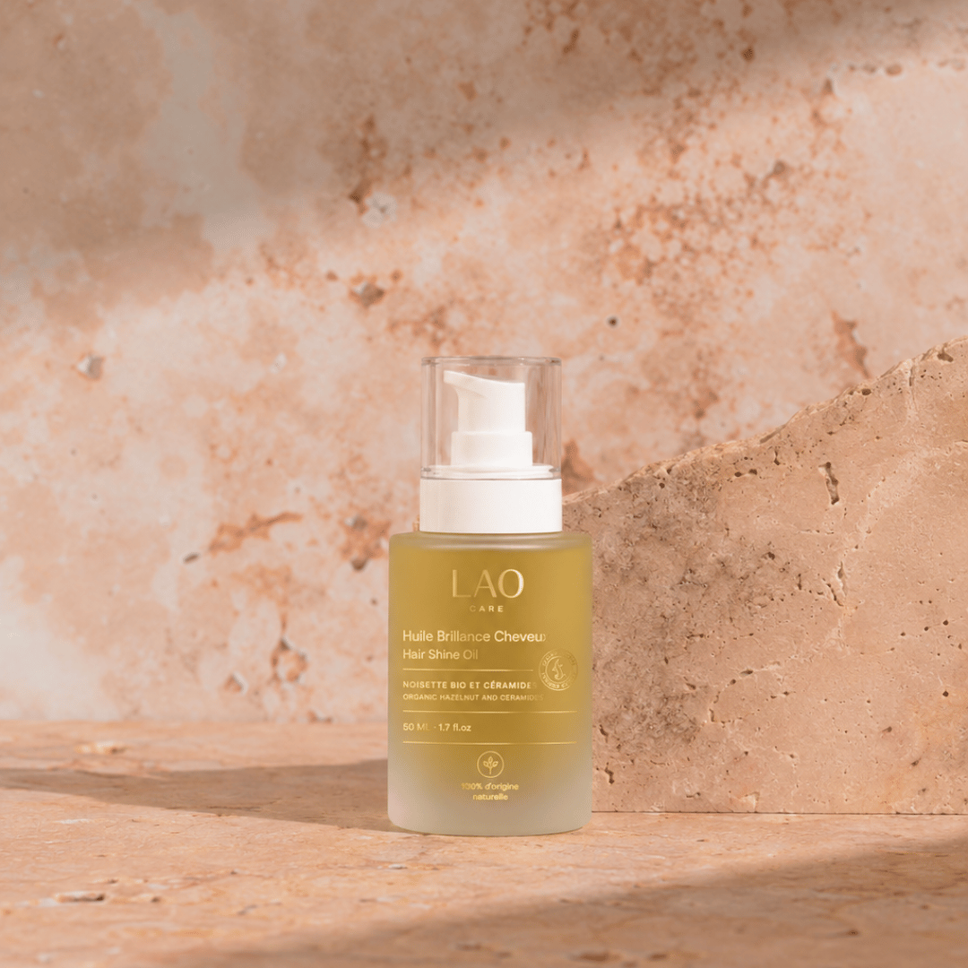 Aceite Capilar Brillo LAO Care, frasco de vidrio con dosificador de 50 ml sobre piedra beige